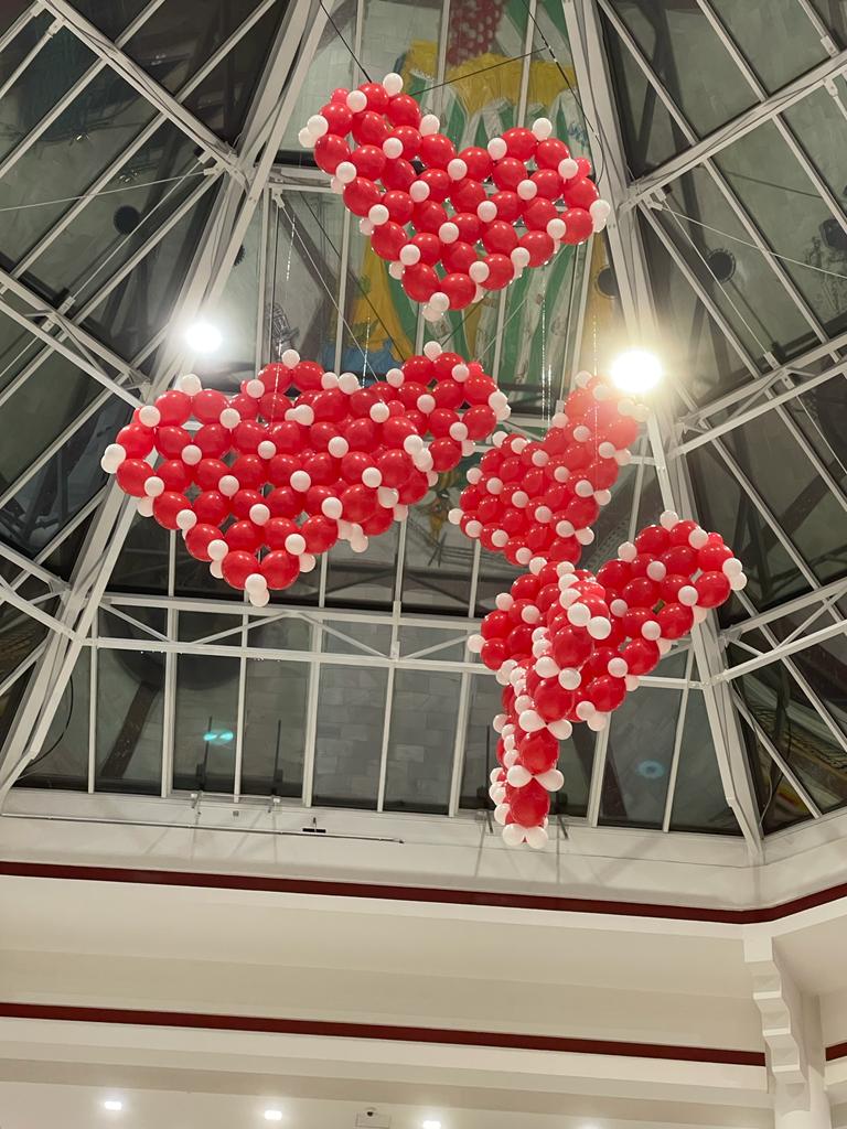 Rote Ballonherzen als hängende Atrium-Installation in einem Einkaufszentrum