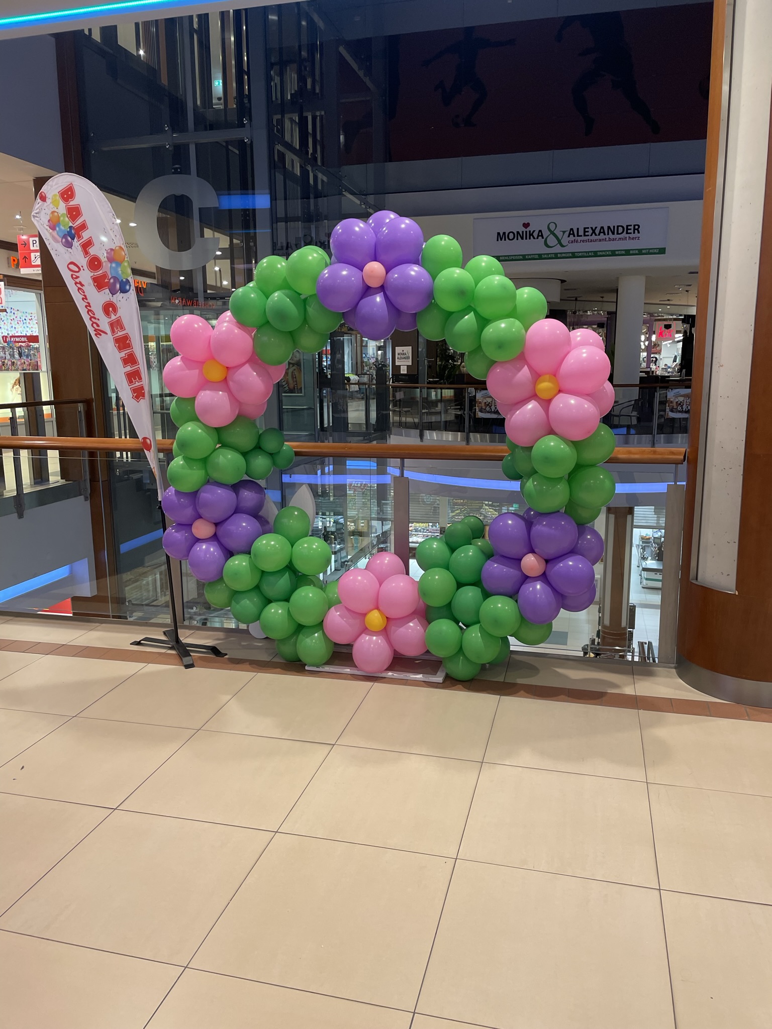 Großer floraler Ballonrahmen in Grün, Rosa und Lila für eine Promotion im Einkaufszentrum