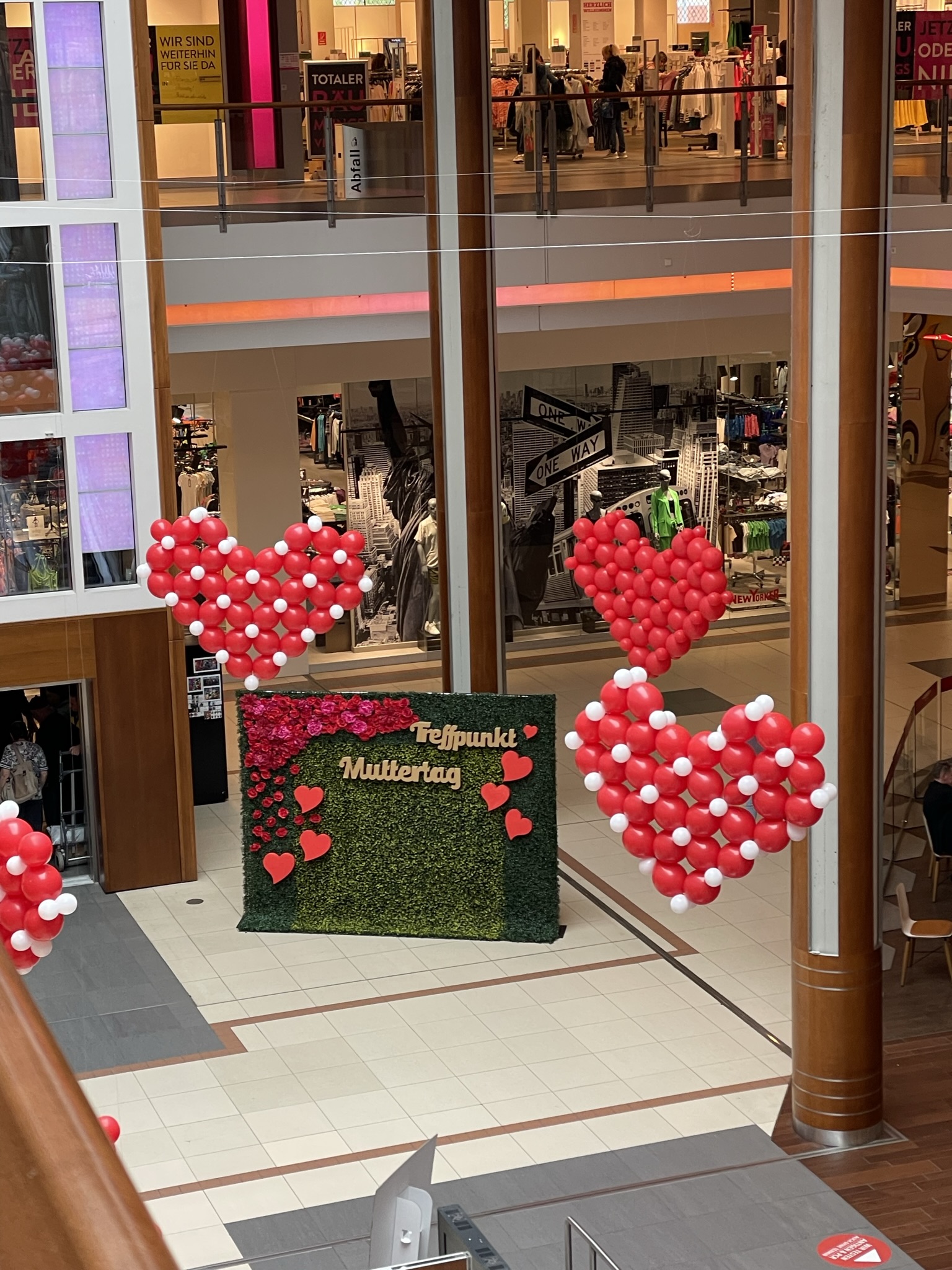 Muttertags-Fotopoint mit Herzballons und begrüntem Hintergrund in einem Einkaufszentrum