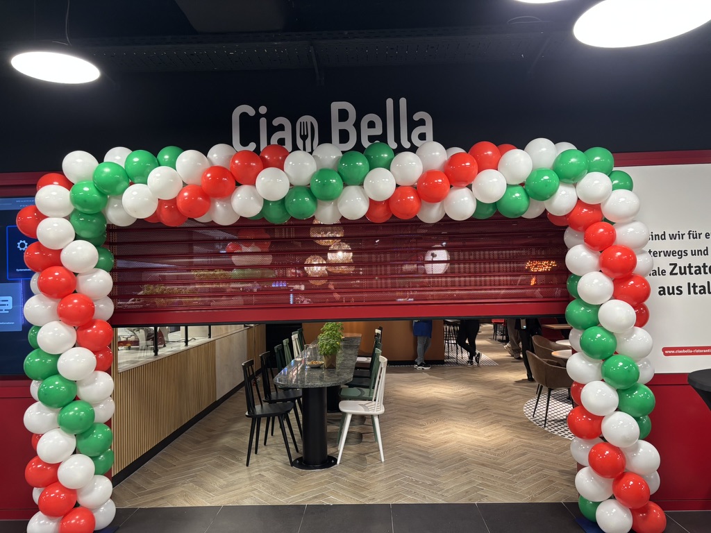 Ballonbogen in Rot, Weiß und Grün vor einem Restaurant