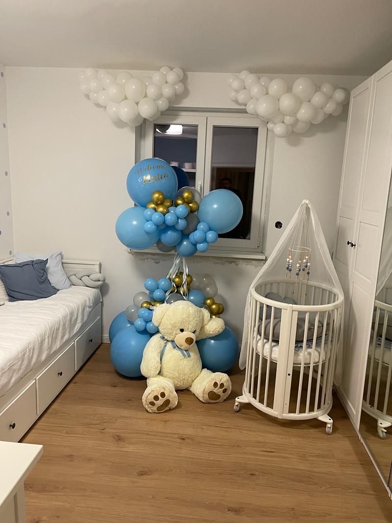 Babyzimmer mit blauer Ballondekoration, Teddybär und weißen Wolkenballons