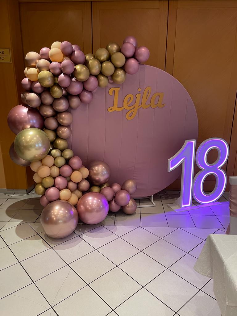 Rosé-goldenes Setup zum 18. Geburtstag mit Namenswand und Leuchtzahl